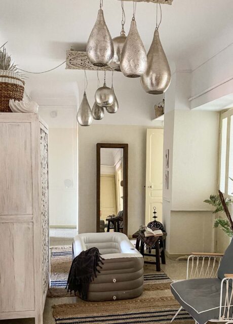 Aufblasbare Badewanne in einem gemütlichen, boho-inspirierten Raum mit hängenden silbernen Lampen.