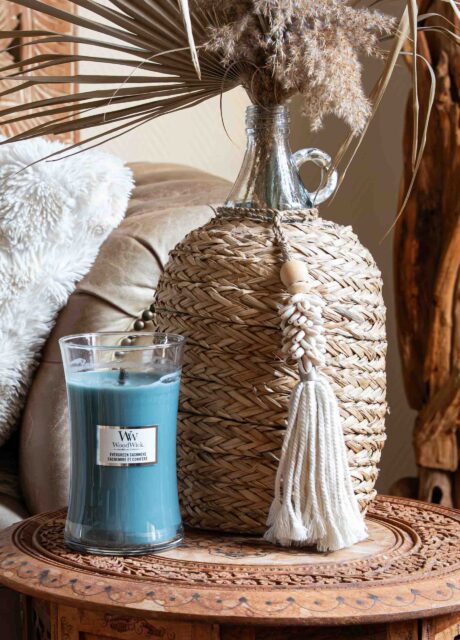 Duftkerze im Glas mit Holzdocht in ruhiger Boho Wohnszene